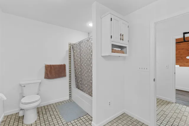 a bathroom with a toilet and a shower