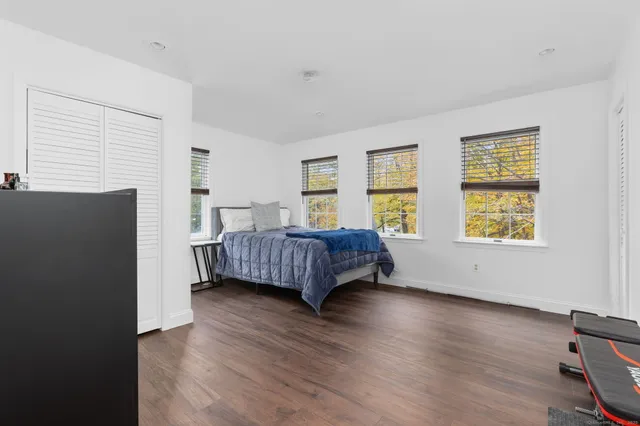 a bedroom with a bed and wooden floor