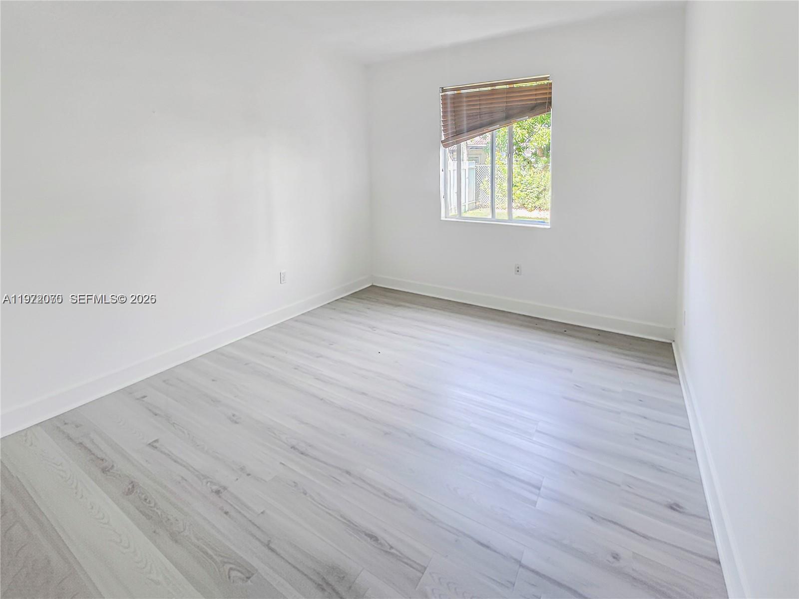 15843 Southwest 139th Street Miami, FL 33196 - Photo 11 of 39 an empty room with wooden floor and windows