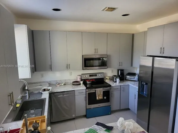 a kitchen with stainless steel appliances a sink a stove and a microwave