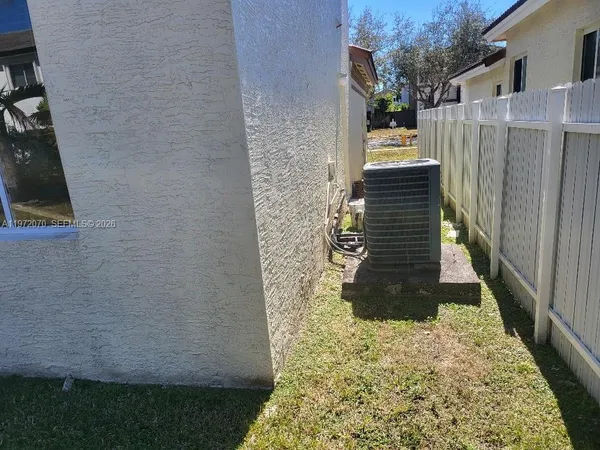 a view of a chair and table in the back yard of the house