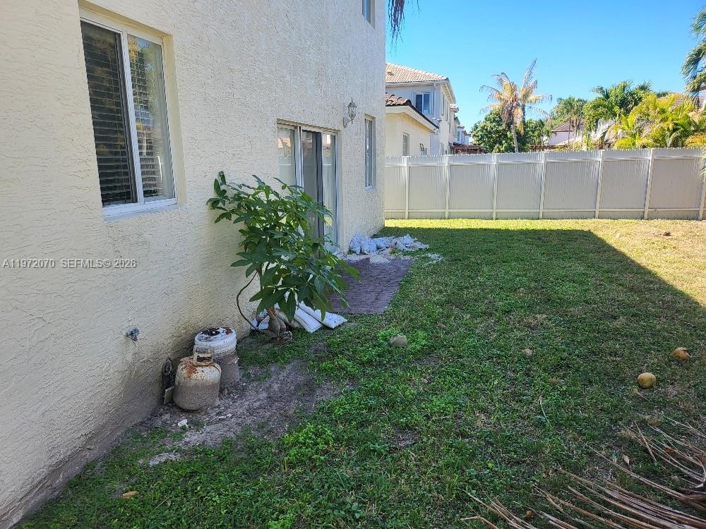 15843 Southwest 139th Street Miami, FL 33196 - Photo 6 of 39 a view of a chair and table in the back yard of the house