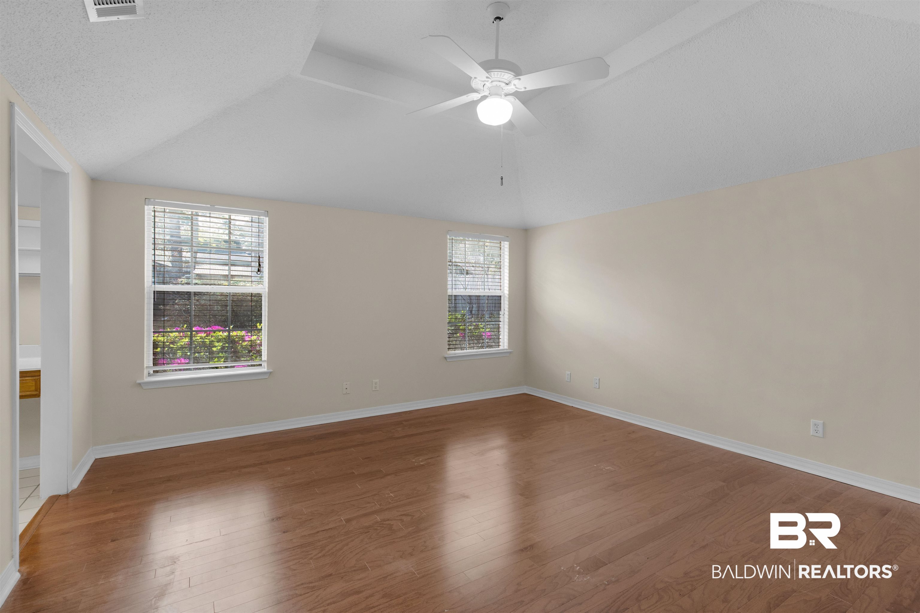 7225 Smithfield Road East Mobile, AL 36695 - Photo 15 of 27 Empty room with lofted ceiling, wood finished floors, a wealth of natural light, and ceiling fan