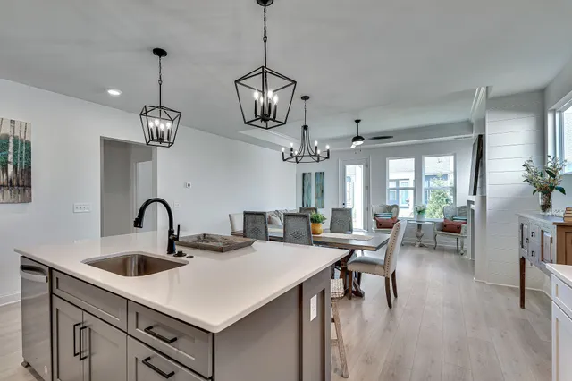 a kitchen with stainless steel appliances a table chairs and white cabinets