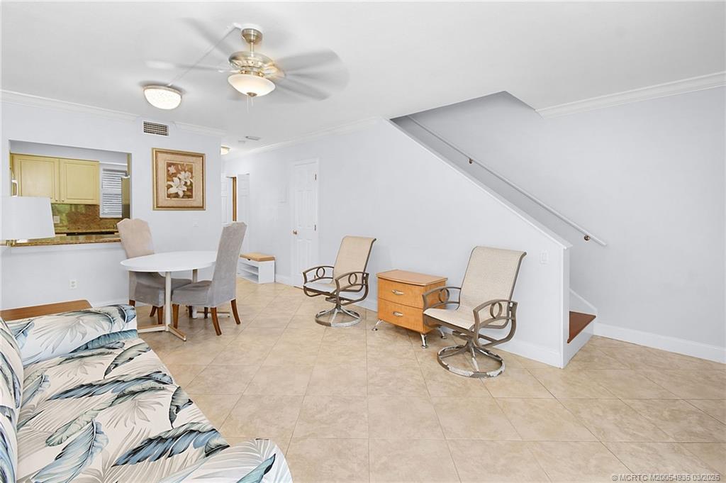 3129 Southeast Indian Street, Unit 3 Stuart, FL 34997 - Photo 14 of 28 a living room with furniture and a chandelier