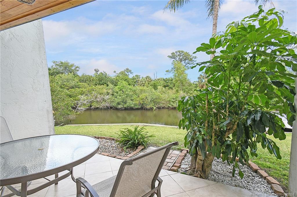3129 Southeast Indian Street, Unit 3 Stuart, FL 34997 - Photo 16 of 28 a view of a backyard with plants and a lake view