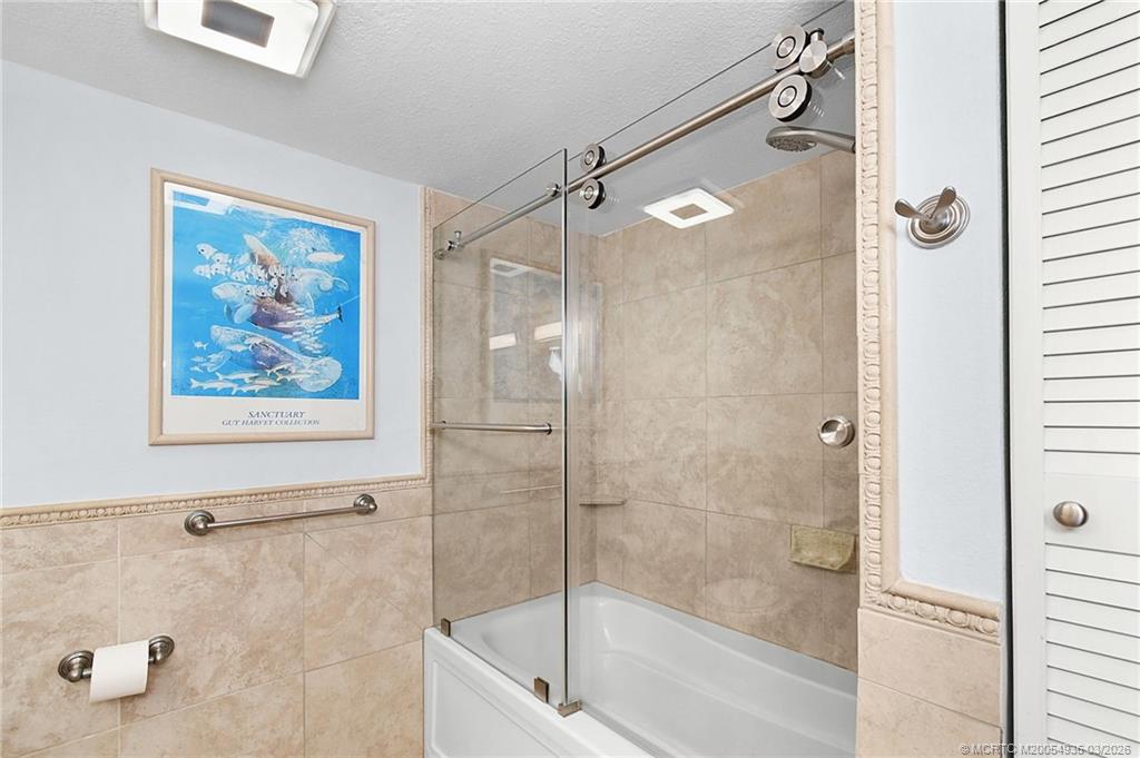 3129 Southeast Indian Street, Unit 3 Stuart, FL 34997 - Photo 20 of 28 a bathroom with a glass shower door