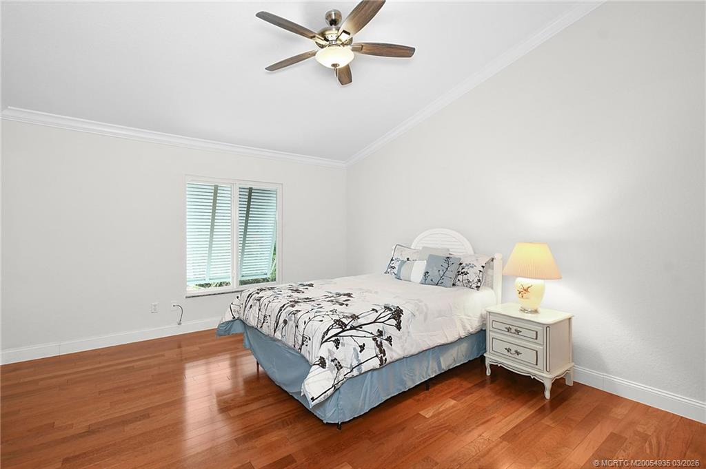 3129 Southeast Indian Street, Unit 3 Stuart, FL 34997 - Photo 24 of 28 a bedroom with a bed and wooden floor