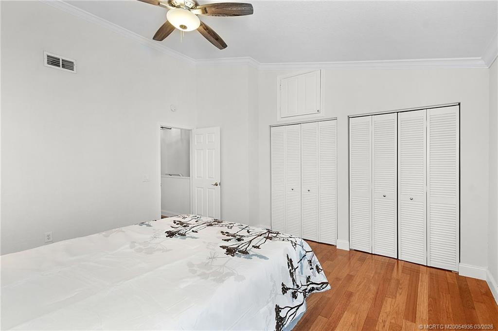 3129 Southeast Indian Street, Unit 3 Stuart, FL 34997 - Photo 25 of 28 a bedroom with a bed and a ceiling fan
