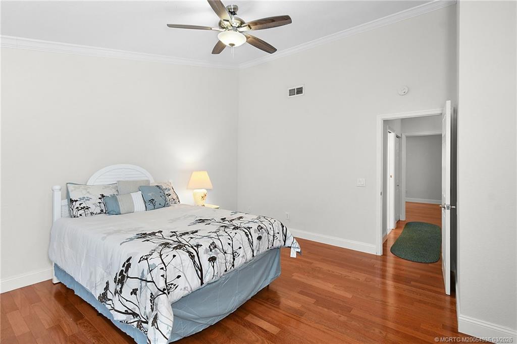 3129 Southeast Indian Street, Unit 3 Stuart, FL 34997 - Photo 26 of 28 a bedroom with a bed and wooden floor
