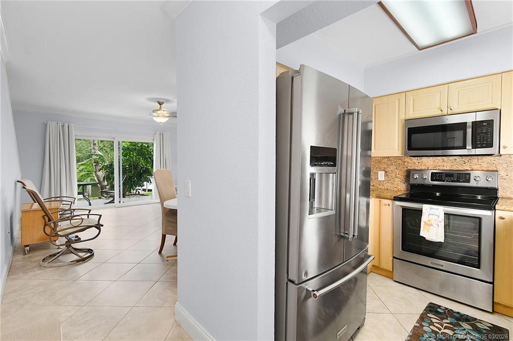 3129 Southeast Indian Street, Unit 3 Stuart, FL 34997 - Photo 5 of 28 a kitchen with stainless steel appliances a refrigerator and a stove top oven