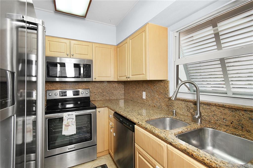3129 Southeast Indian Street, Unit 3 Stuart, FL 34997 - Photo 8 of 28 a kitchen with stainless steel appliances a stove a sink a microwave and cabinets