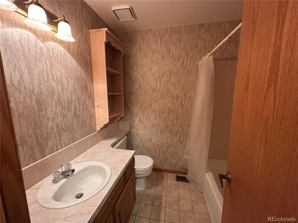 a bathroom with a sink a toilet and shower curtain