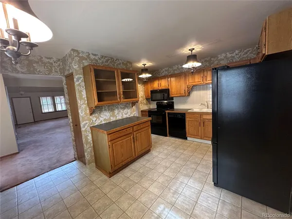 a large kitchen with stainless steel appliances granite countertop a refrigerator and a stove top oven