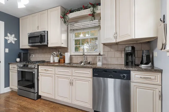 a kitchen with stainless steel appliances granite countertop a stove a sink and a microwave