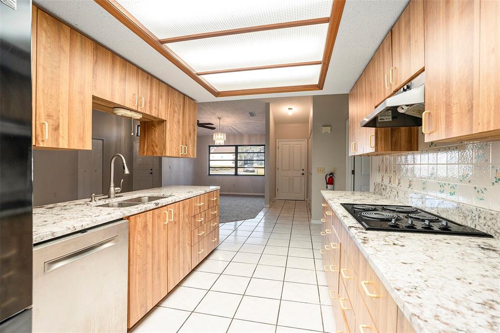 7320 Auburn Lane New Port Richey, FL 34654 - Photo 13 of 28 a kitchen with stainless steel appliances granite countertop a sink stove and cabinets