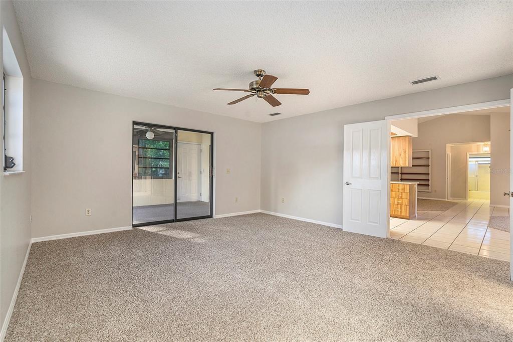 7320 Auburn Lane New Port Richey, FL 34654 - Photo 15 of 28 an empty room with chandelier fan and windows