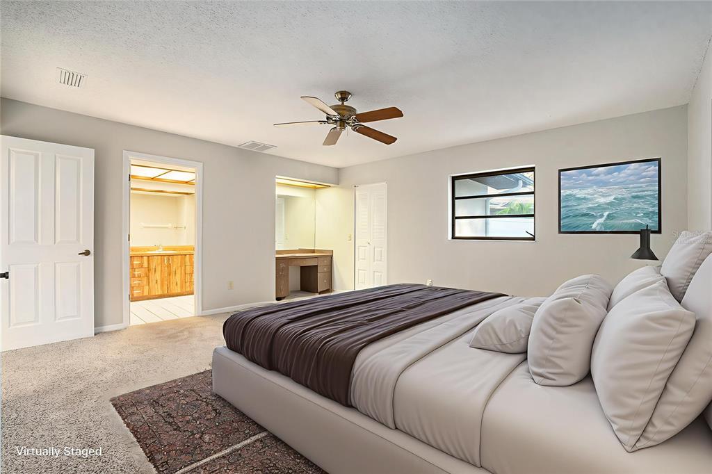 7320 Auburn Lane New Port Richey, FL 34654 - Photo 16 of 28 a bedroom with a large bed and a chandelier