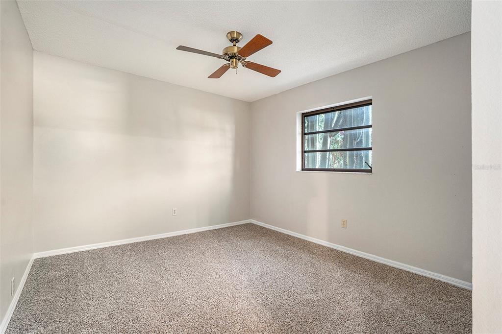 7320 Auburn Lane New Port Richey, FL 34654 - Photo 20 of 28 an empty room with ceiling fan and windows