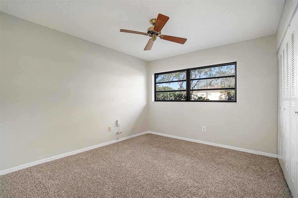 7320 Auburn Lane New Port Richey, FL 34654 - Photo 23 of 28 an empty room with windows and ceiling fan