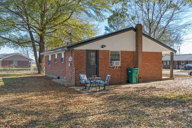a backyard of a house with table and chairs