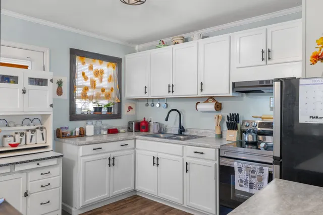 a kitchen with cabinets appliances a sink and a window