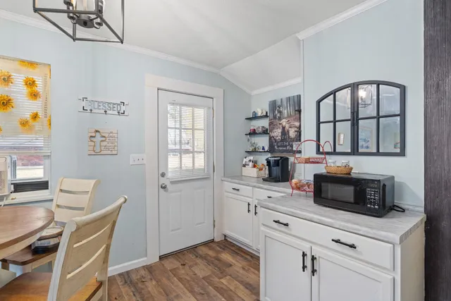 a kitchen with stainless steel appliances white cabinets and wooden floor