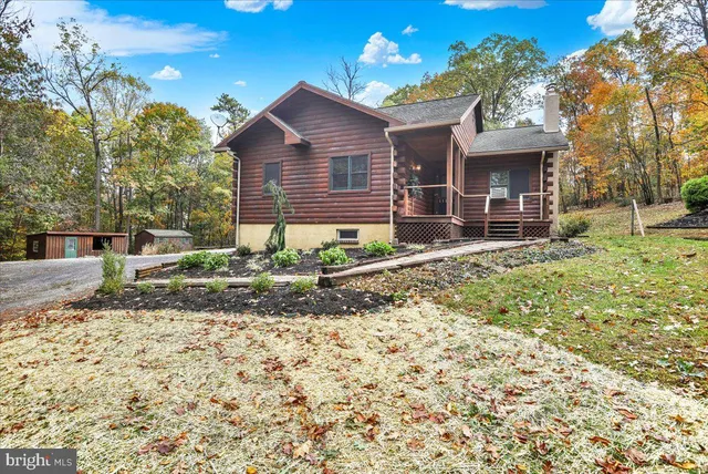 a view of a house with a yard and large tree