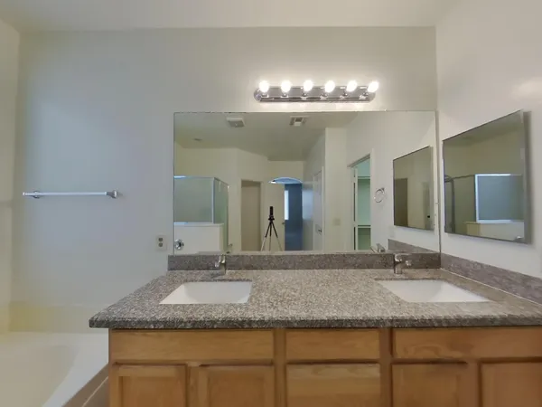 a bathroom with a granite countertop sink and a large mirror