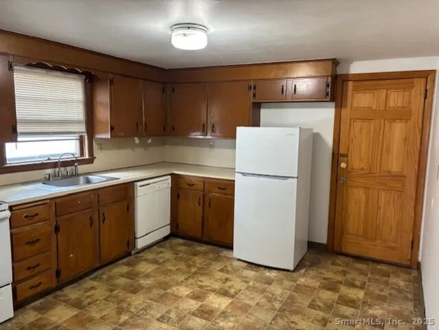 a kitchen with a refrigerator sink and cabinets