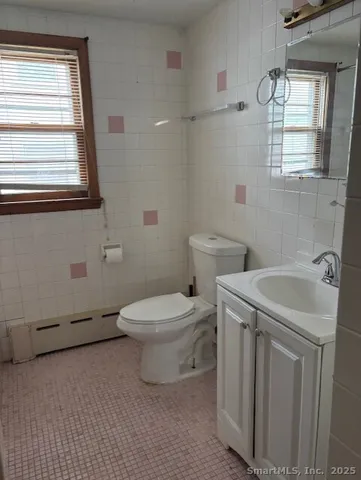 a bathroom with a sink a toilet and window