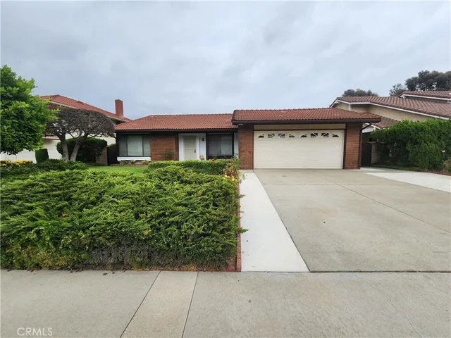 a front view of a house with a garden and garage