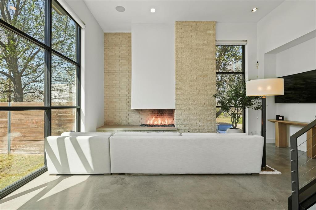 6 Vanguard Way Dallas, TX 75243 - Photo 4 of 35 a living room with large couches a flat screen tv and a large window