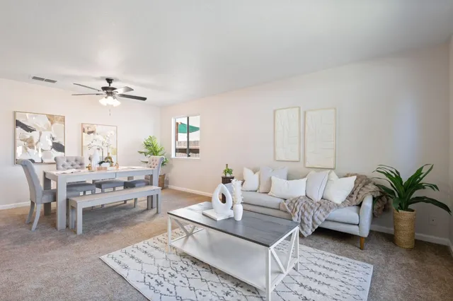 a living room with furniture a chandelier and a rug