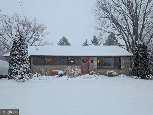 a front view of a house with a yard covered in snow