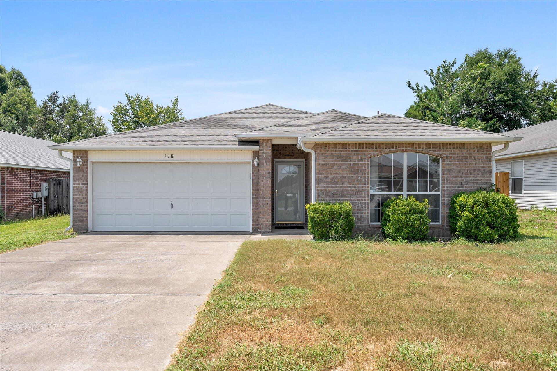 118 Sandstone Trail Crestview, FL 32539 - Photo 1 of 33 a front view of a house with a yard and potted plants