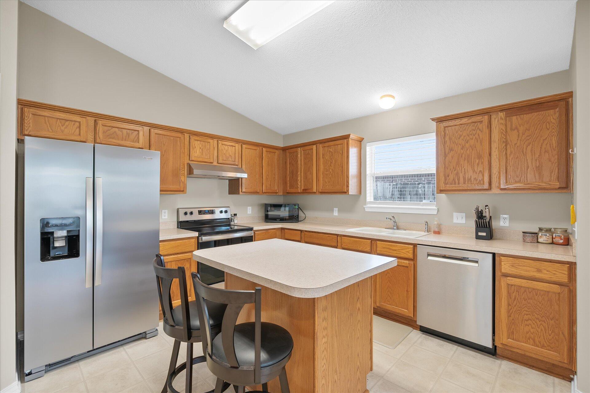 118 Sandstone Trail Crestview, FL 32539 - Photo 16 of 33 a kitchen with stainless steel appliances a sink a stove a refrigerator cabinets and a window