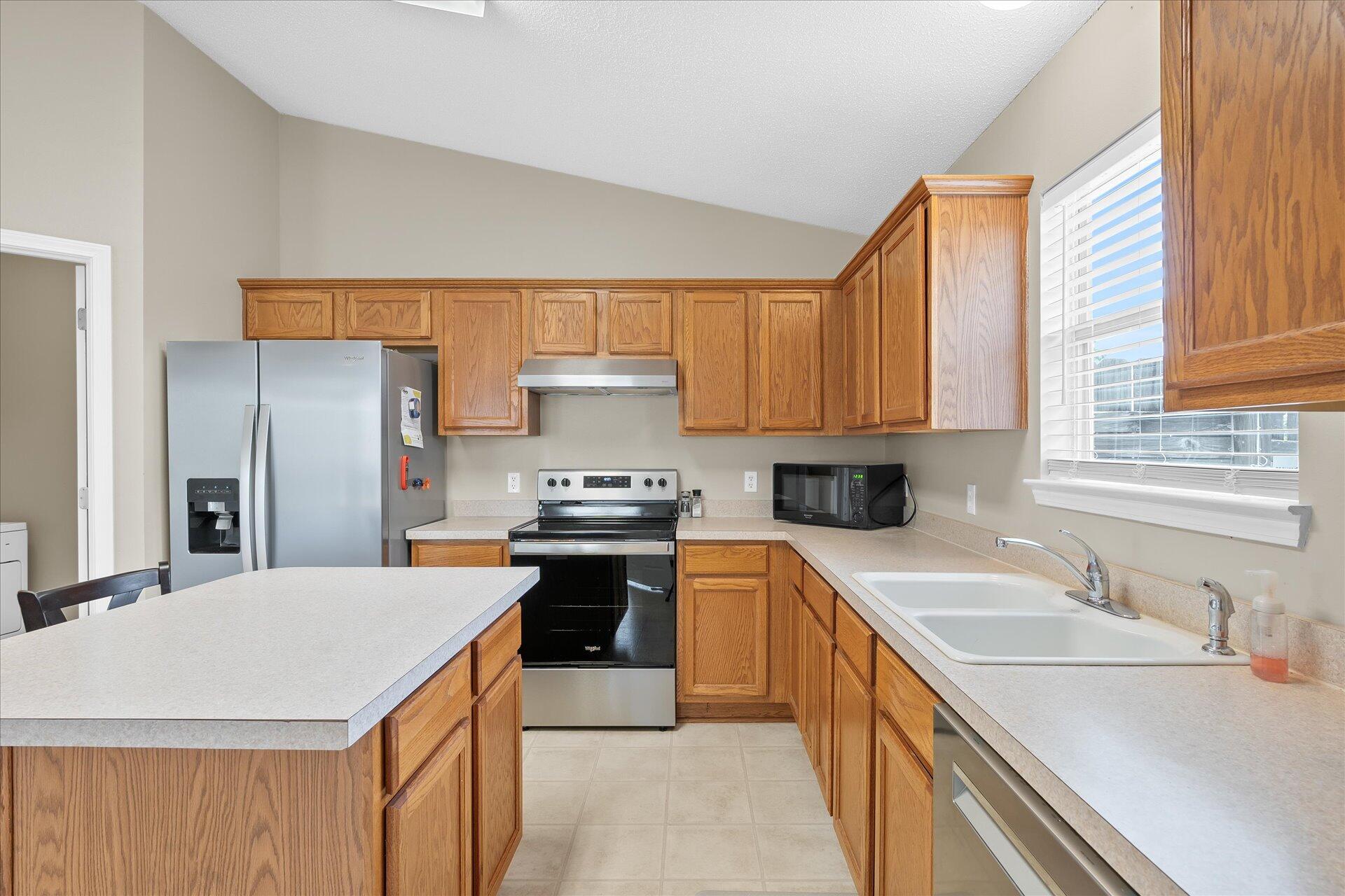 118 Sandstone Trail Crestview, FL 32539 - Photo 17 of 33 a kitchen with stainless steel appliances a sink stove refrigerator and a window
