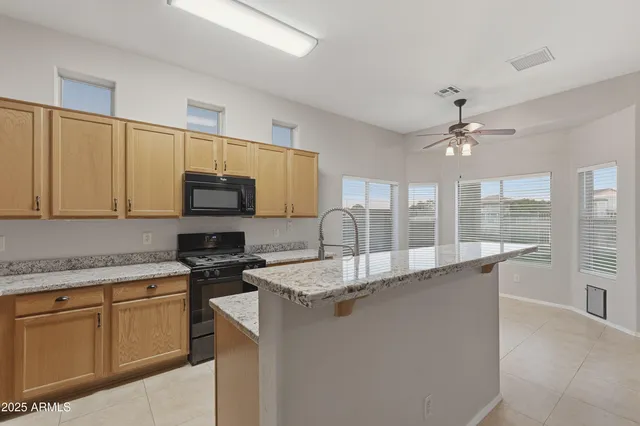 a kitchen with stainless steel appliances granite countertop a sink a stove and cabinets