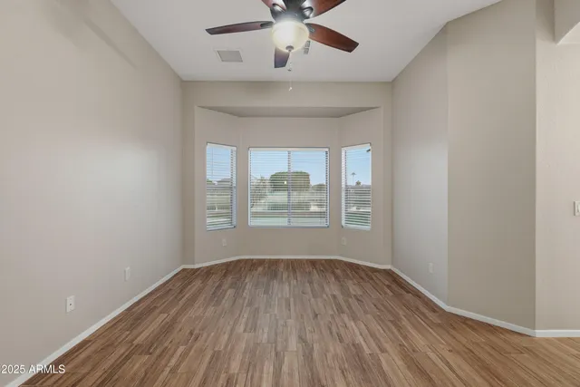 a view of room with window ceiling fan and hardwood floor
