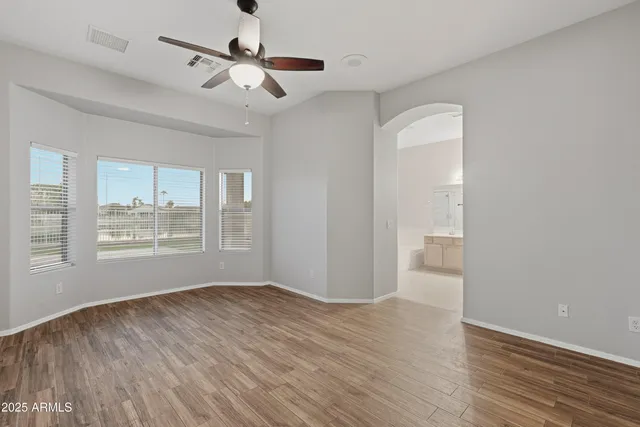 a view of an empty room and window a ceiling fan