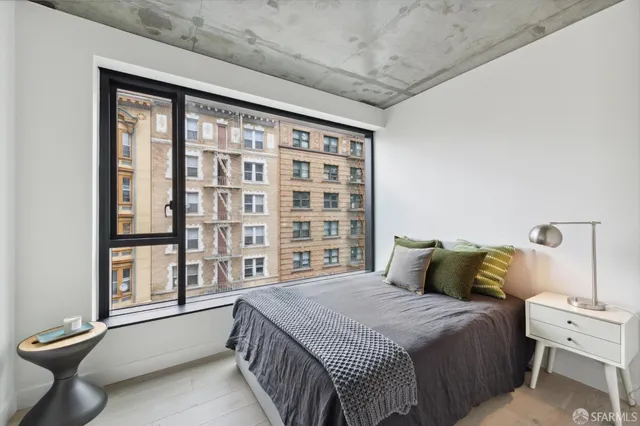 a bedroom with a bed and a large window