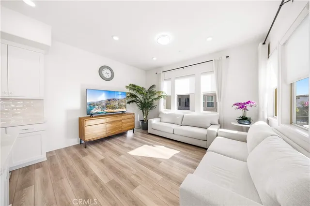 a dining hall with stainless steel appliances kitchen island granite countertop a table chairs and a refrigerator