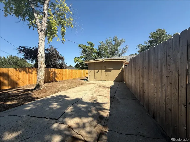 a view of a yard with wooden fence