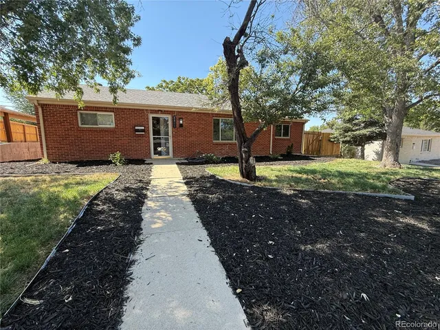 a front view of a house with a yard and trees