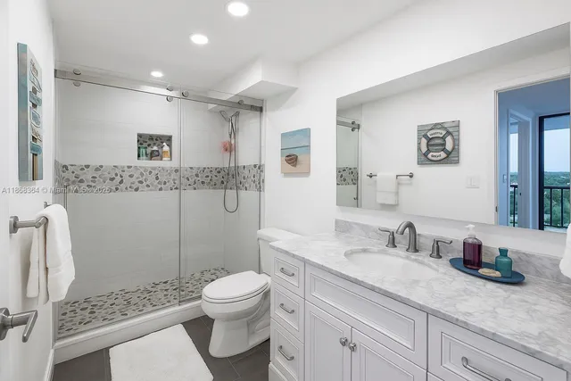 a bathroom with a granite countertop sink toilet and shower
