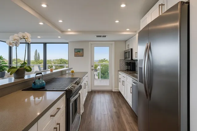 a kitchen with stainless steel appliances granite countertop a sink a stove and a refrigerator