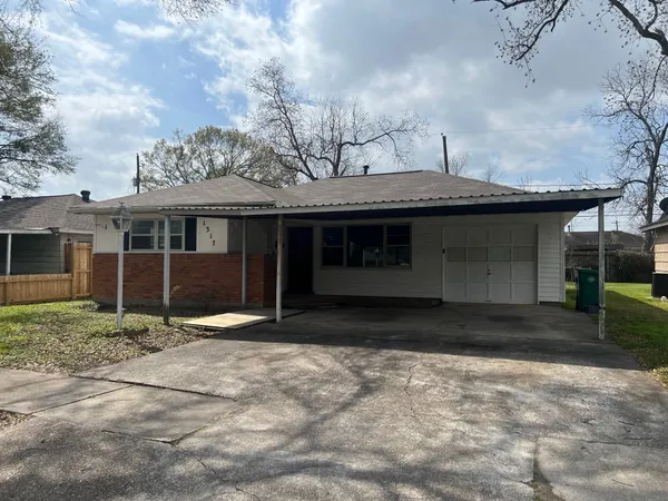 a front view of a house with a garden and trees