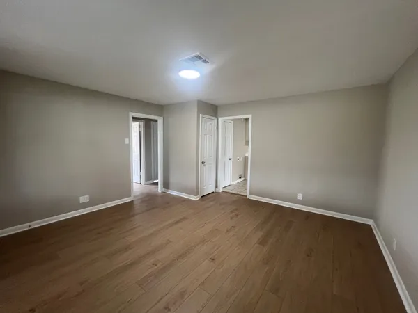 a view of an empty room with wooden floor