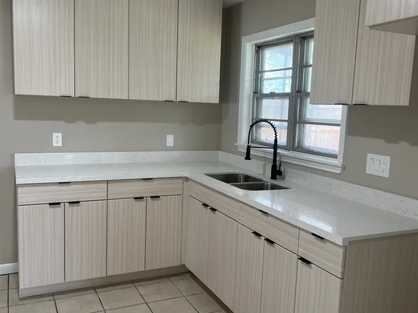 a kitchen with white cabinets a sink and dishwasher